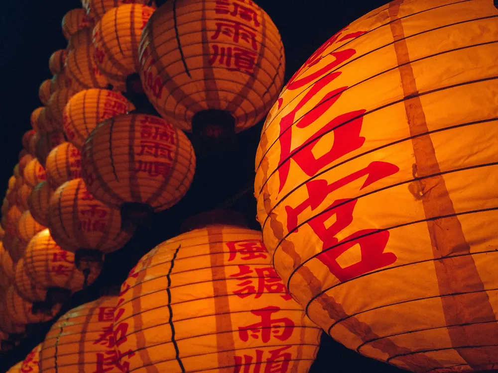 Glowing orange lanterns with Chinese calligraphy at a lantern festival