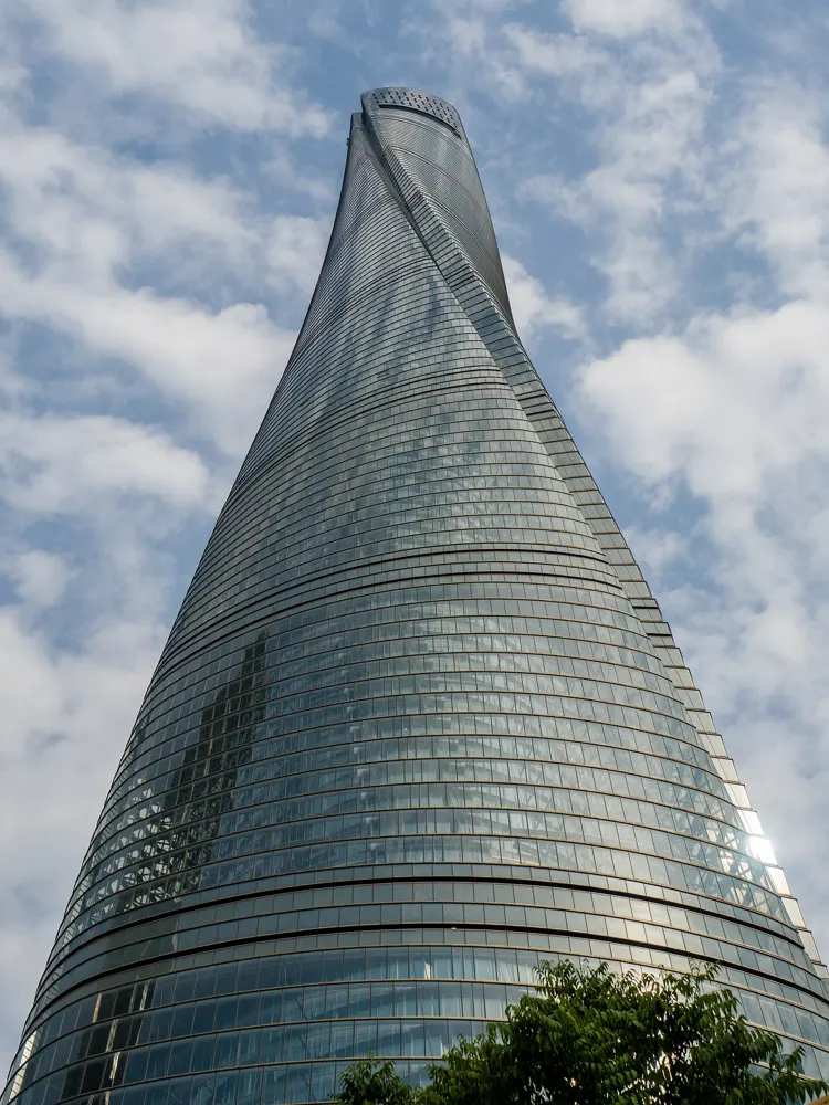 The twisting glass Shanghai Tower against a blue sky